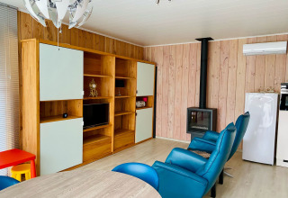 Salón moderno en Chalet del Familiepark Goolderheide, Bélgica, con sillones azules y estufa de leña.