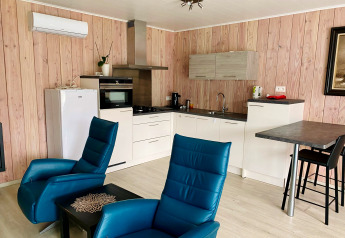 Cocina moderna y sala de estar con sillones azules en un chalet del Family park Goolderheide, Bélgica.