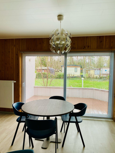 Sala da pranzo moderna nello Chalet al Familiepark Goolderheide, Belgio, con vista sul giardino dalle finestre.