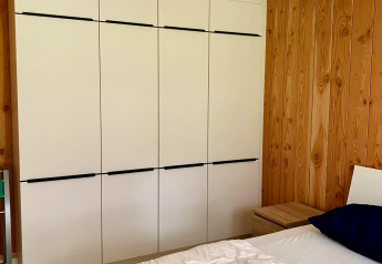 Dormitorio en un chalet del Familiepark Goolderheide, Bélgica, con armario moderno y paredes de madera.