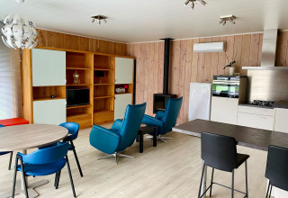 Séjour lumineux d'un chalet à Familiepark Goolderheide, Belgique, avec mobilier moderne, cuisine et salon.