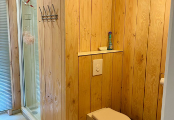 Bagno in uno chalet con pannelli in legno, WC a parete e doccia presso Chalet a Familiepark Goolderheide.