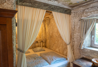 Camera accogliente con letto a tende e decorazione rustica nel Hobbit huisje, Familiepark Goolderheide, Belgio.