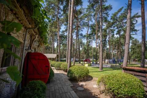 View from the Hobbit huisje at Familiepark Goolderheide in Belgium, showing garden, trees, and a playground.