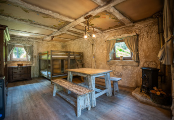 Indvendigt billede af Hobbit huisje, en hyggelig træhytte med køjeseng, spisebord og komfur i Belgien.