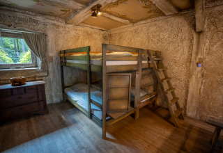 Cozy room with bunk beds and wooden decor at Hobbit huisje in Familiepark Goolderheide, Belgium.