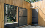 Façade d'un chalet moderne en bois avec de grandes fenêtres à Familiepark Goolderheide en Belgique.