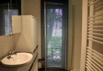 Baño moderno en un chalet de Familiepark Goolderheide, Bélgica, con lavabo, armario y persianas en la ventana.