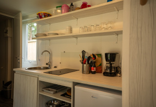 Modern kitchenette at Cooc Tent Deluxe in Familiepark Goolderheide, Belgium with coffee maker and utensils.