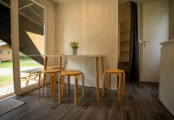Interior de la tienda Cooc tent deluxe en Familiepark Goolderheide, Bélgica, con mesa y taburetes.
