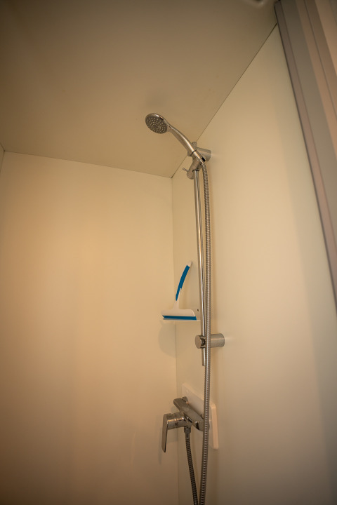 Modern shower in Cooc tent deluxe at Familiepark Goolderheide, Belgium, equipped with handheld showerhead.