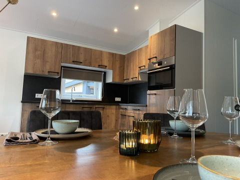 Cucina moderna e tavolo con candele al Wood Cottage nel parco vacanze De Witte Berg nei Paesi Bassi.