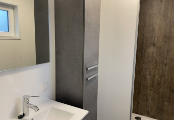 Baño moderno en Wood Cottage del Holiday Park De Witte Berg con lavabo, espejo y cabina de ducha.