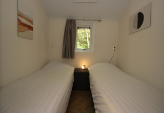 Slaapkamer in Velthorst Hottub bij EuroParcs Ruinen in Nederland, met twee aparte bedden en eenvoudige stijl.