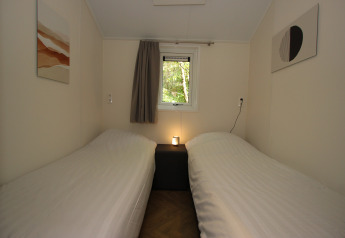 Slaapkamer in Velthorst Hottub bij EuroParcs Ruinen in Nederland, met twee aparte bedden en eenvoudige stijl.