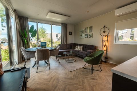 Salon lumineux au Vakantiechalet comfort+ de Vakantiepark De Wiedense Meren, Pays-Bas, avec mobilier contemporain.