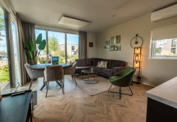Soggiorno luminoso in Vakantiechalet comfort+ al Vakantiepark De Wiedense Meren nei Paesi Bassi con arredo moderno.