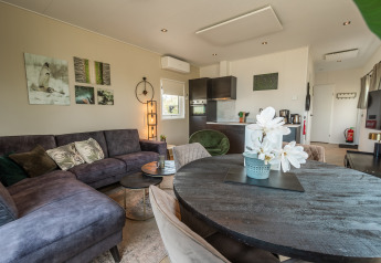 Sala y comedor modernos del Vakantiechalet comfort+ en Vakantiepark De Wiedense Meren, Países Bajos, bien decorado.