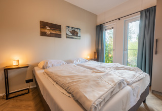 Soveværelse i Vakantiechalet comfort+ på Vakantiepark De Wiedense Meren, Holland, med dobbeltseng.