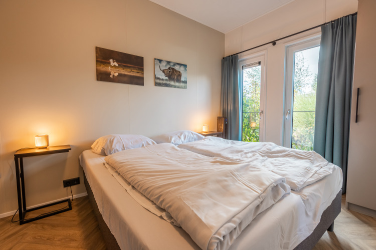 Schlafzimmer im Vakantiechalet comfort+ im Vakantiepark De Wiedense Meren, Niederlande, mit Doppelbett.