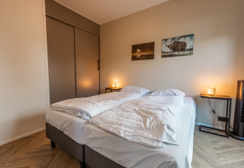 Comfortabele lodge slaapkamer met twee eenpersoonsbedden, wanddecoratie en sfeerverlichting in Nederland.