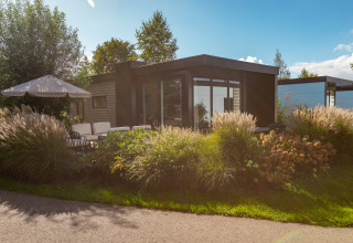 Moderne Lodge mit Terrasse und viel Grün bei Vakantiechalet comfort+ im Vakantiepark De Wiedense Meren, Niederlande.
