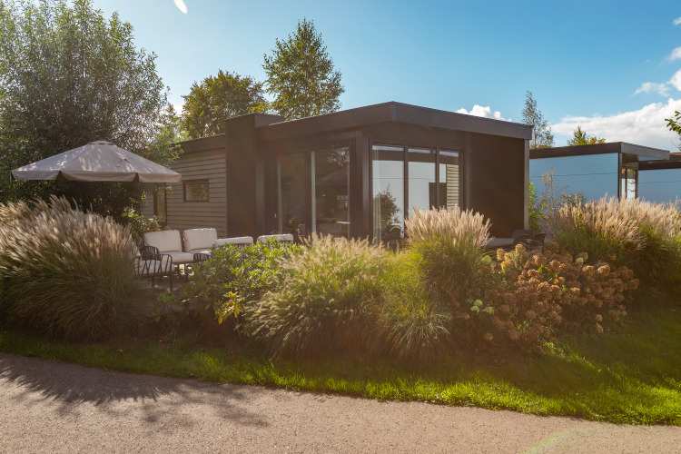 Moderne Lodge mit Terrasse und viel Grün bei Vakantiechalet comfort+ im Vakantiepark De Wiedense Meren, Niederlande.