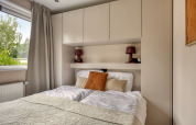 Chambre moderne à la lodge Heideveld du Bospark Ede, Pays-Bas, avec lit et rangements intégrés.