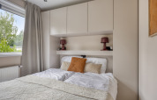 Modern bedroom at Heideveld lodge in Bospark Ede, Netherlands, featuring a bed and built-in wardrobes.