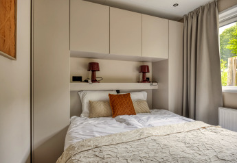 Dormitorio moderno en la cabaña Heideveld en Bospark Ede, Países Bajos, con armarios empotrados y cama doble.