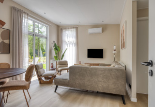 Soggiorno moderno nella lodge Heideveld, Bospark Ede, Paesi Bassi, con ampie finestre e luce naturale.