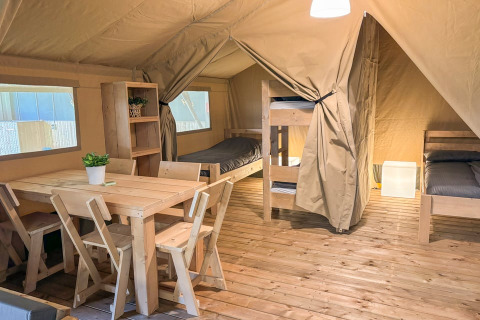 Interior of Safaritent at Glyngore Camping in Denmark featuring wooden furniture, beds, and flooring.