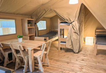 Interno della Safaritent al Glyngore Camping in Danimarca con arredi e letti in legno.