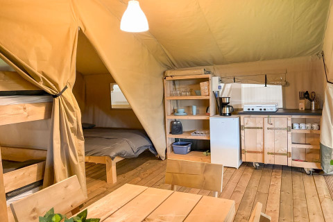 Innenansicht eines Safari-Zeltes mit Küche, Esstisch, Etagenbett und Doppelbett auf Glyngore Camping.