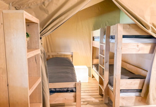 Innenansicht eines Safarizeltes bei Glyngore Camping in Dänemark mit Etagenbetten und Holzboden.