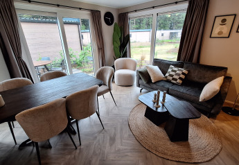 Moderne stue og spisestue med store vinduer i Groeneborg lodge med Hottub på Vakantiepark De Wiltzangh.