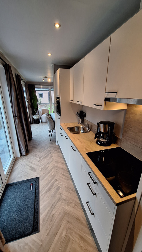 Cucina e soggiorno moderni al Groeneborg lodge con vasca idromassaggio a Vakantiepark De Wiltzangh, Paesi Bassi.