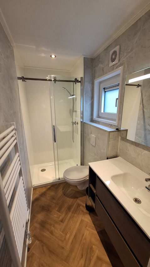 Moderne badkamer in Groeneborg lodge met douche, toilet en lavabo op Vakantiepark De Wiltzangh, Nederland.