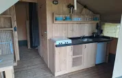 Keukenzone in een safaritent met houten afwerking en sanitair op Camping de Regenboog in Tsjechië.