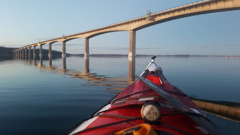 Kayak su acque calme vicino a Glyngore Camping, ponte e riflesso nell'acqua, regione centrale della Danimarca.