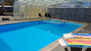 Covered swimming pool with sun loungers at Glyngore Camping holiday park, Central Denmark Region.