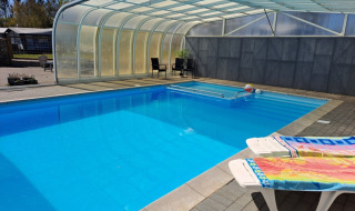 Swimmingpool med overdækning og liggestole ved Glyngøre Camping i Midtjylland, Danmark.