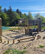 Legeplads med klatrestativer og sand ved Glyngore Camping i Midtjylland, Danmark på en solrig dag.