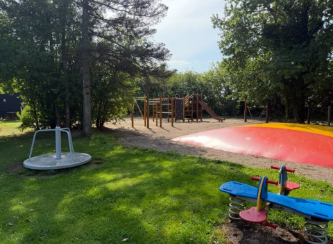Parco giochi con altalena, giostra, cuscino gonfiabile e arrampicata a Himmerland camping, Danimarca.
