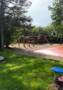 Playground featuring seesaw, roundabout, bouncy pillow and climbing structure at Himmerland camping, Denmark.