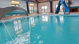 Indoor swimming pool with a slide and waterfall feature at Himmerland camping in North Jutland, Denmark.
