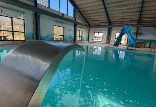 Indendørs swimmingpool med rutsjebane og springvand på Himmerland camping i Nordjylland, Danmark.