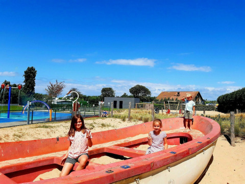 Kinderen spelen in een oude reddingsboot op de speeltuin van Kompas Camping Westende in West-Vlaanderen.