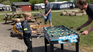 Children and adults playing foosball outdoors at Himmerland camping holiday park in North Jutland, Denmark.