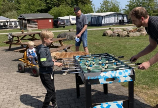 Bambini e adulti giocano a calcetto all'aperto al campeggio Himmerland nel Nord Jutland, Danimarca.